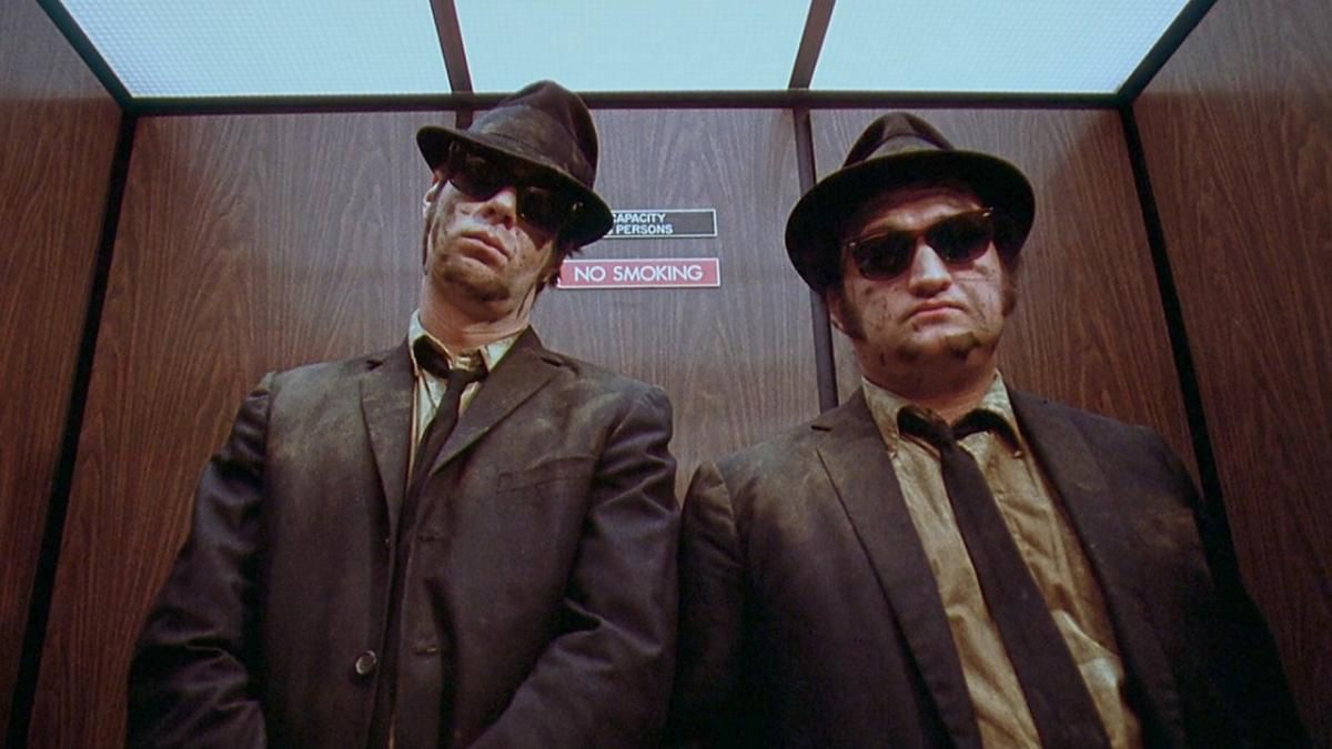 Jake and Elwood Blues in black suits, hats and sunglasses