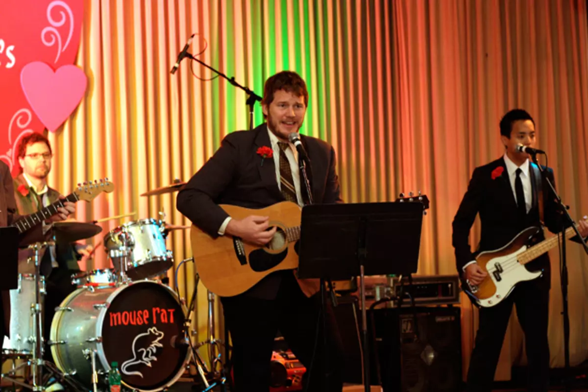 Andy Dwyer singing and playing acoustic guitar with Mouse Rat onstage